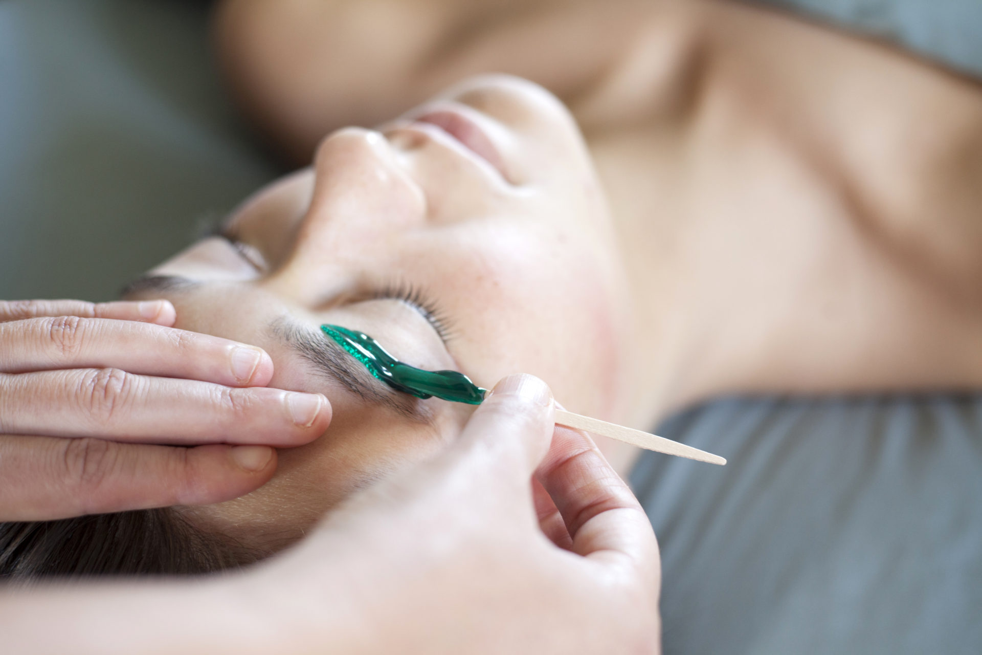 Sarah Becker giving an eyebrow waxing treatment